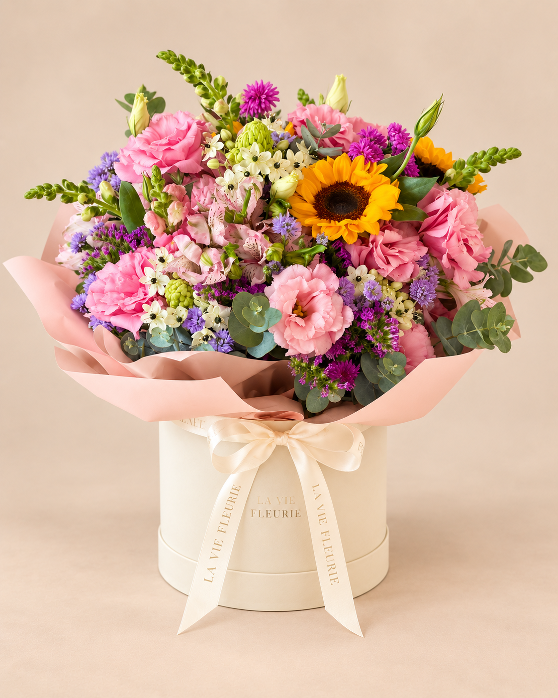 Box Celine com flores em tons de rosa, lilás e branco, girassóis em destaque e folhagens de eucalipto